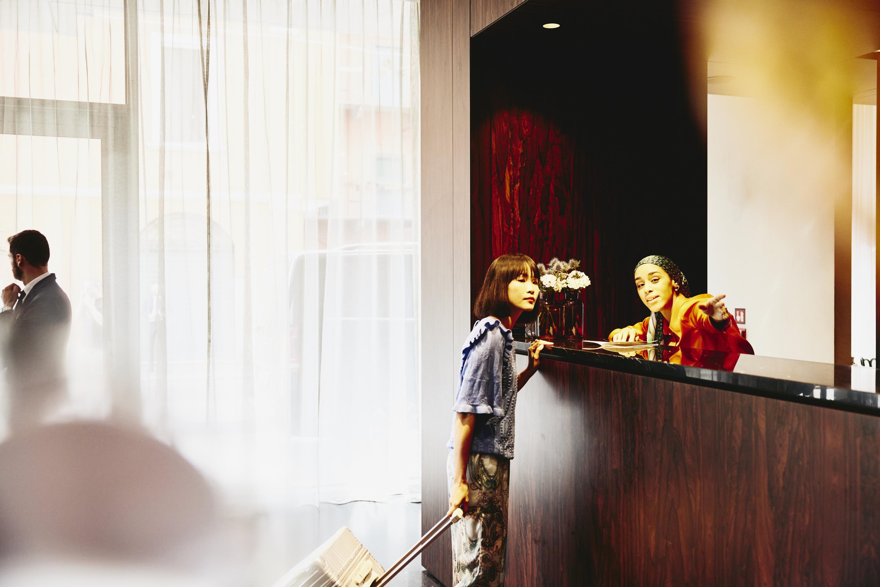 Hotel receptions giving directions to a hotel guest.
