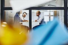 People having a meeting in an office. Primary colors: turquoise and yellow.