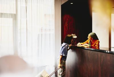 Smiling woman receptionist helping a hotel guest.