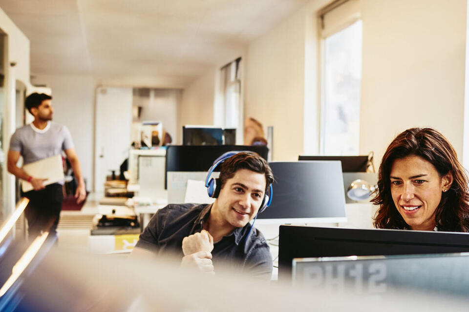 people smiling and speaking in a kitchen area
